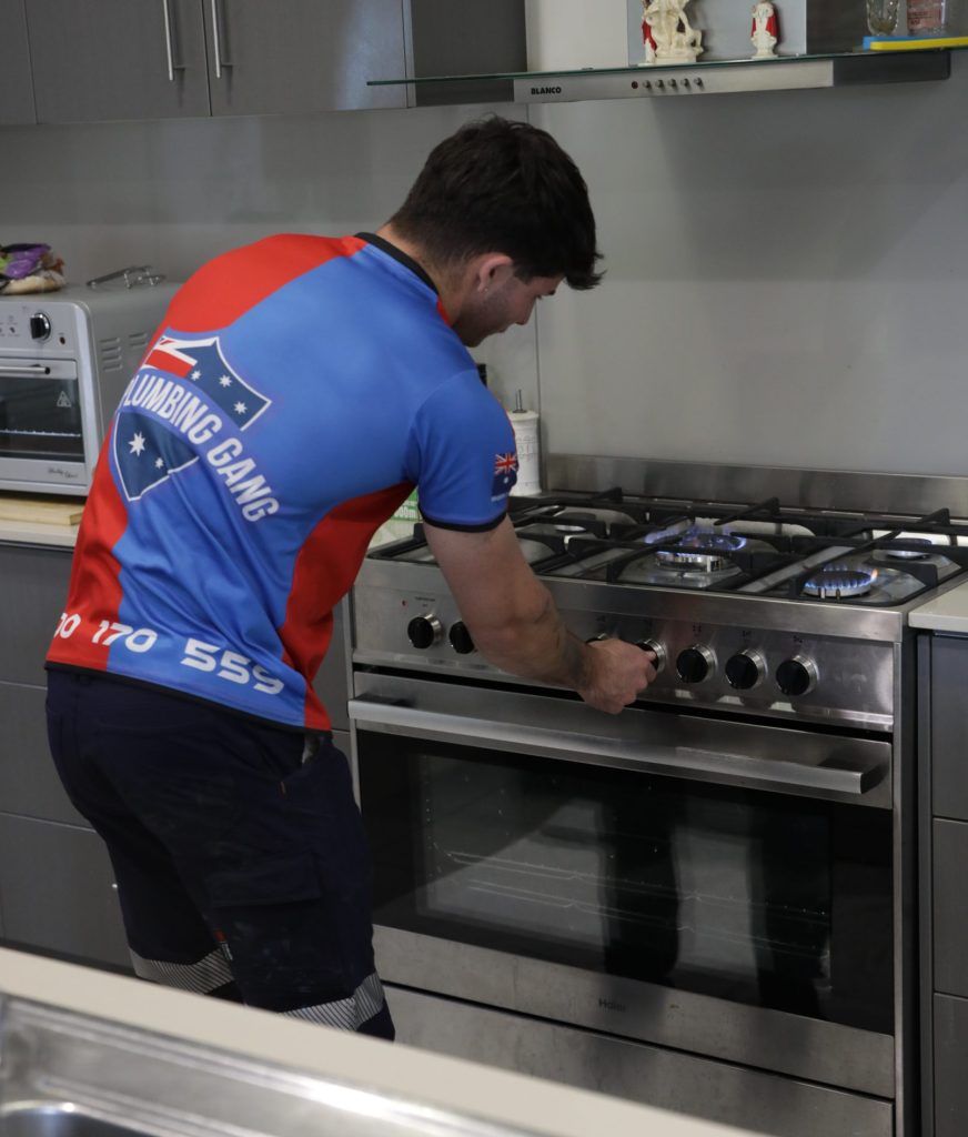 Plumber installing a gas cooktop