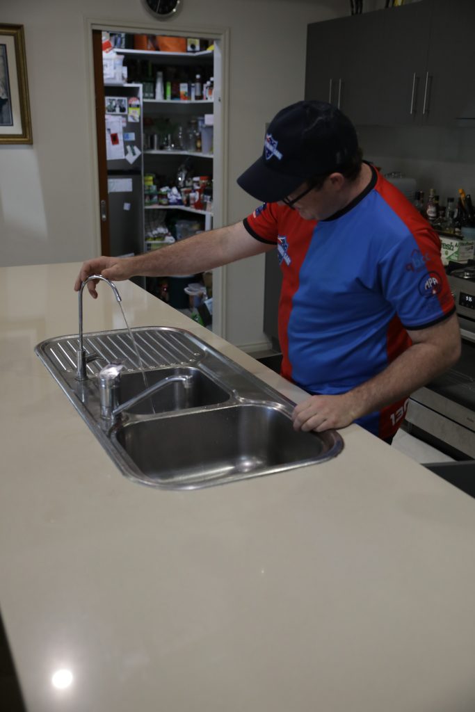 Plumber installing a kitchen mixer tap