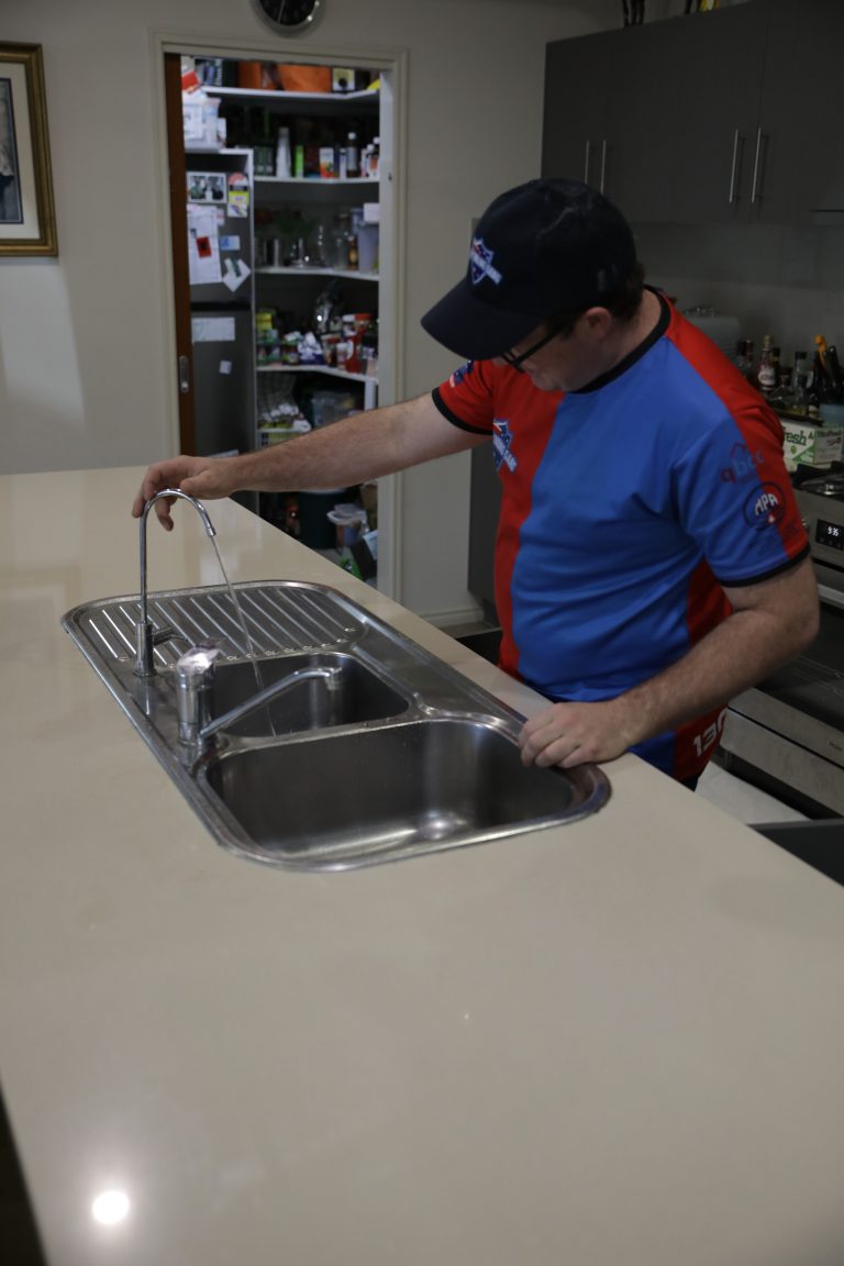 Plumber installing a kitchen mixer tap
