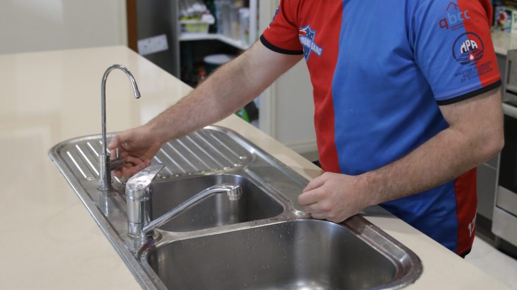 Plumber replacing a kitchen tap