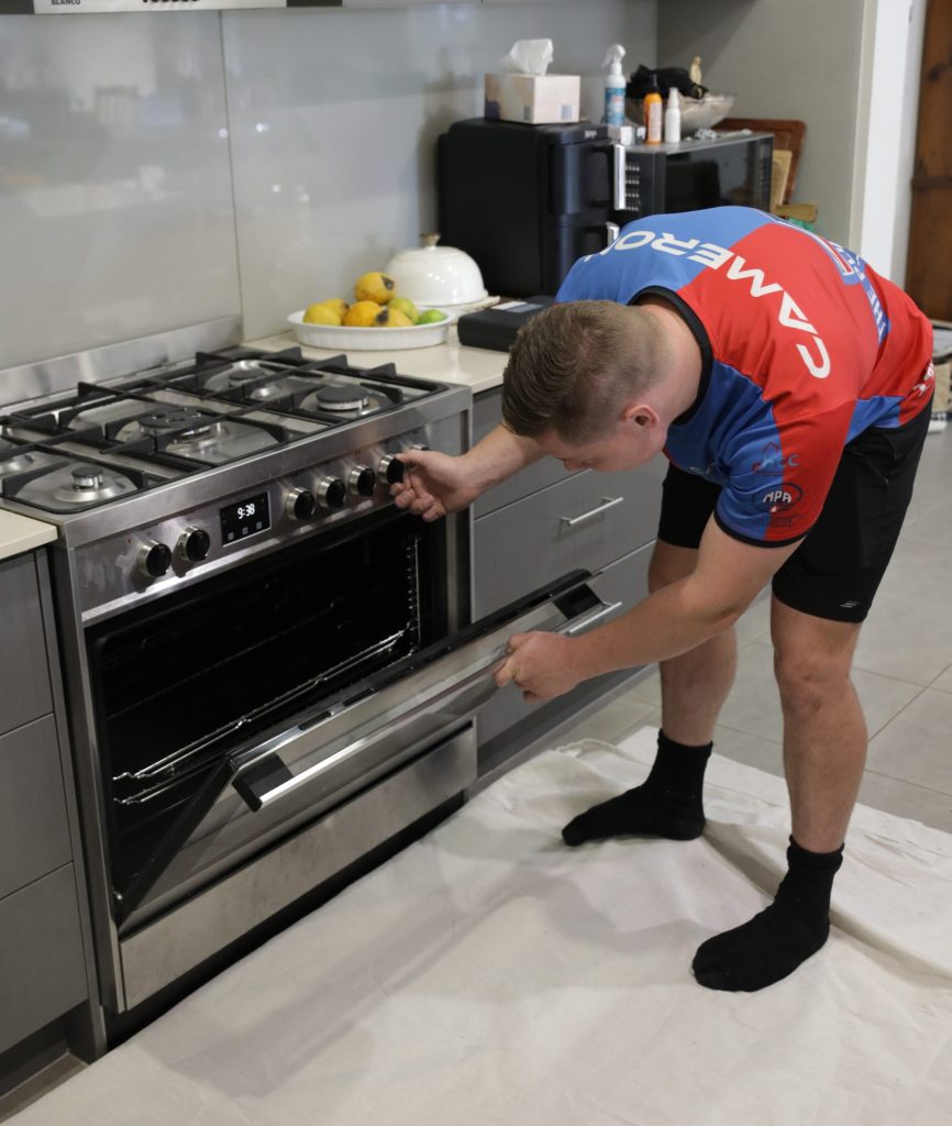 Gasfitter testing a gas oven