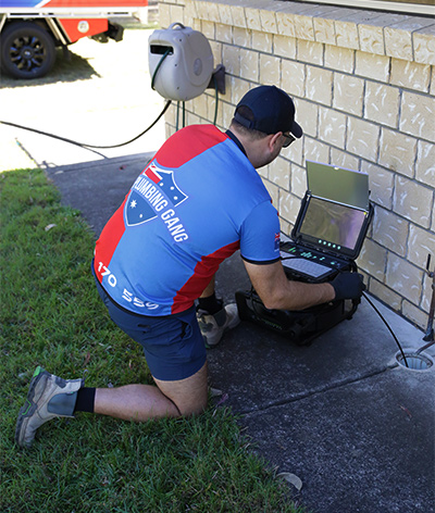 Plumber running a CCTV drain camera inspection