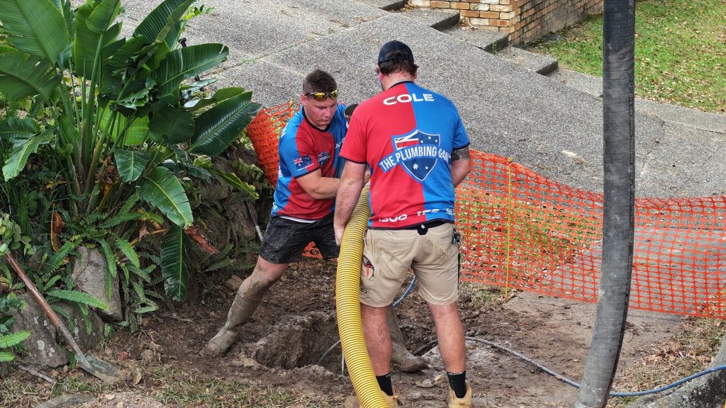 Plumbers digging to repair an underground pipe