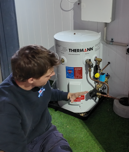 Plumber servicing a heat pump hot water system