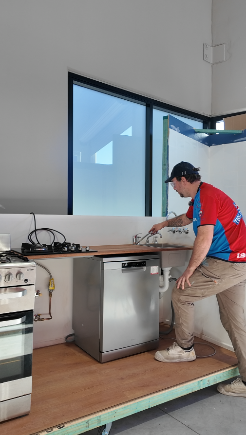 Plumber fixing a leaking pipe in a bathroom