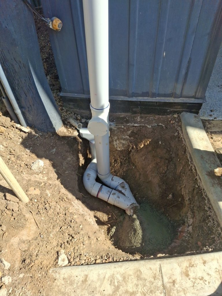 Excavated stormwater drain connection at a downpipe