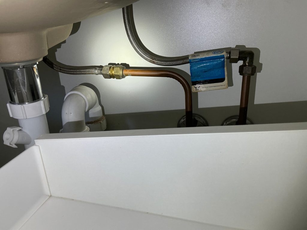 Under-sink water filter installed in a kitchen cabinet